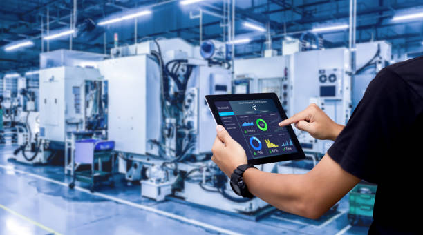 Hands holding tablet on automation manufacturing machine