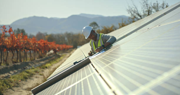 solar energy management in electricity sustainability, solar panels. Worker, employee or technician on renewable energy farm