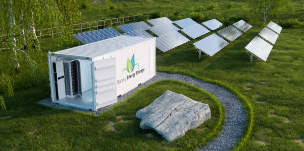 View of the battery energy storage located in an open industrial container on a lush lawn with a photovoltaic power plant
