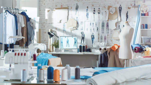 Hanging Clothes, Sewing Machine and Various Sewing Related Items on the Table, Mannequins Standing, Colorful Fabrics