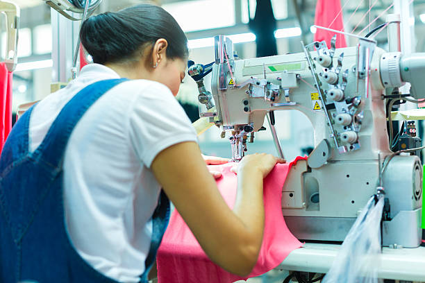 worker in a manufacturing factory sewing with sewing machine