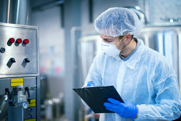 Technologist expert taking parameters from industrial machine in food production plant