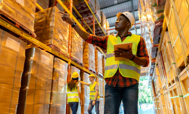 warehouse supervisor standing with digital tablet check stock in large warehouse distribution center