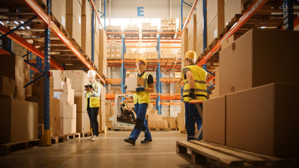 Retail Warehouse full of Goods, Workers Scan and Sort Packages, Move Inventory with Pallet Trucks and Forklifts