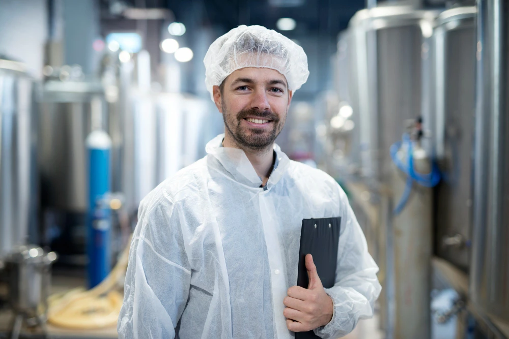 Smart technology adoption at a small food manufacturer for improved efficiency and quality control Food production supervisor in sanitary gear at a smart-enabled small food manufacturing facility